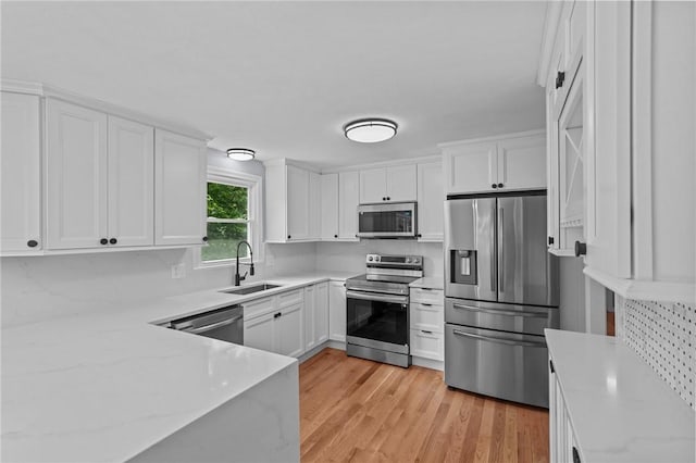 7 Antony Ave, Bristol, RI 02809 - kitchen featuring stainless steel appliances, white cabinets, decorative backsplash, and light stone countertops