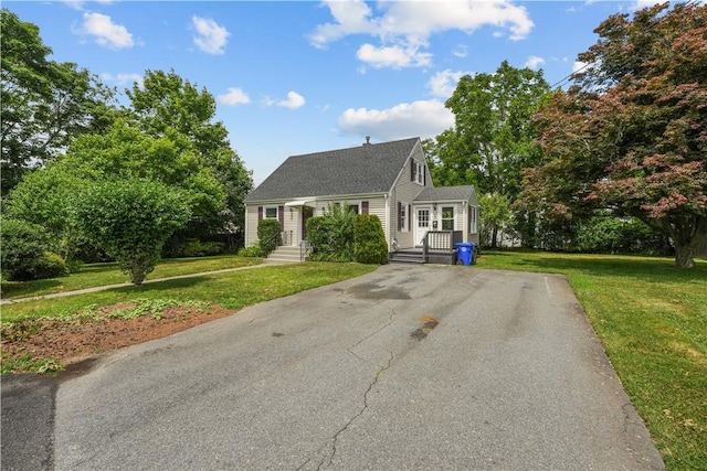 14 Gladding St, Bristol, RI 02809 - view of front of home featuring a front lawn, roof with shingles, and a chimney