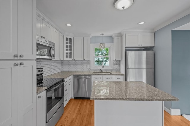 14 Gladding St, Bristol, RI 02809 - kitchen featuring stainless steel appliances, white cabinets, light wood-type flooring, tasteful backsplash, and recessed lighting