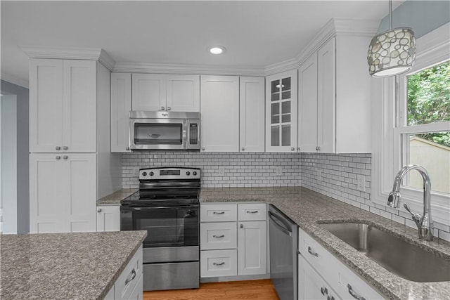 14 Gladding St, Bristol, RI 02809 - kitchen with stainless steel appliances, white cabinetry, glass insert cabinets, tasteful backsplash, and recessed lighting