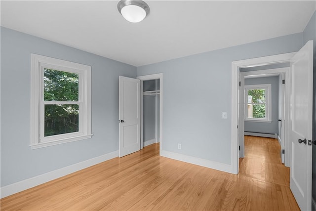 14 Gladding St, Bristol, RI 02809 - unfurnished bedroom featuring baseboard heating, light wood-type flooring, and a closet