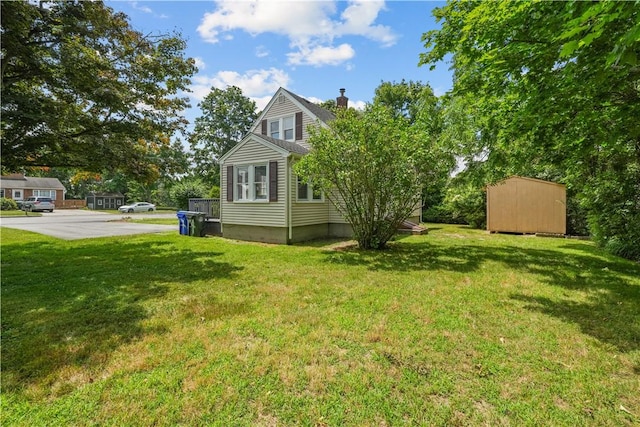 14 Gladding St, Bristol, RI 02809 - view of side of property featuring a chimney, a storage shed, and a lawn