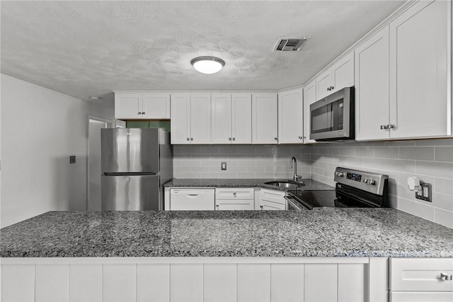 190 White Ave, Warwick, RI 02889 - kitchen with stainless steel appliances, backsplash, white cabinets, and dark stone countertops