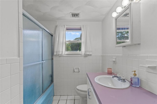 190 White Ave, Warwick, RI 02889 - bathroom featuring tile walls, tile patterned flooring, vanity, enclosed tub / shower combo, and a wainscoted wall