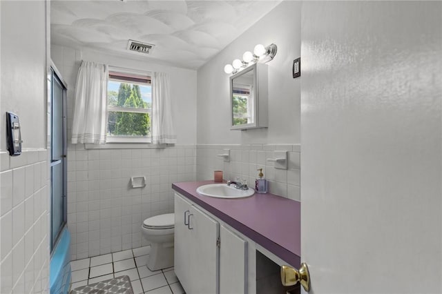 190 White Ave, Warwick, RI 02889 - bathroom with tile walls, tile patterned floors, vanity, a shower with door, and a wainscoted wall