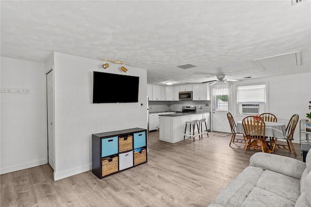 190 White Ave, Warwick, RI 02889 - living area with ceiling fan, light wood-style floors, cooling unit, attic access, and a textured ceiling