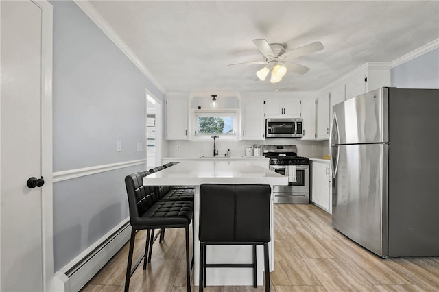 62 Bristol Ave, Pawtucket, RI 02861 - kitchen featuring appliances with stainless steel finishes, a baseboard radiator, a ceiling fan, light countertops, and white cabinets
