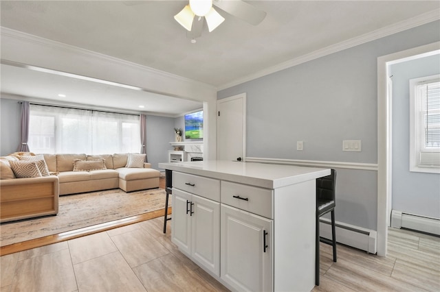 62 Bristol Ave, Pawtucket, RI 02861 - kitchen with a baseboard heating unit, ceiling fan, white cabinetry, ornamental molding, and light countertops