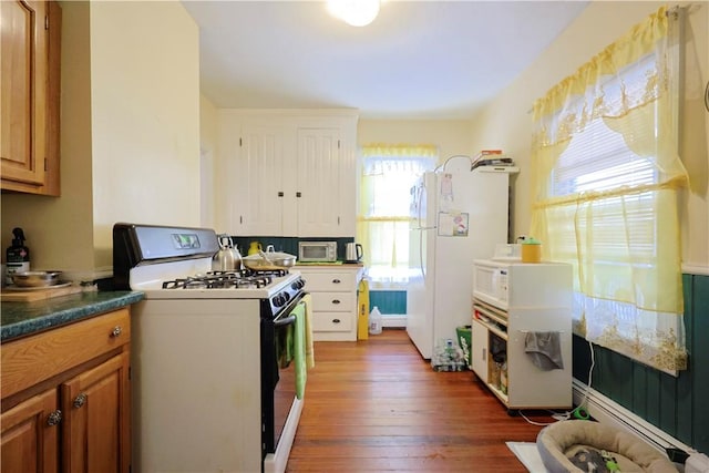 10 Walnut St, East Providence, RI 02914 - kitchen featuring white appliances, dark wood-style floors, brown cabinetry, and dark countertops
