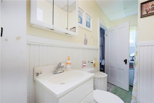 10 Walnut St, East Providence, RI 02914 - bathroom featuring wainscoting, vanity, tile patterned flooring, and a drop ceiling