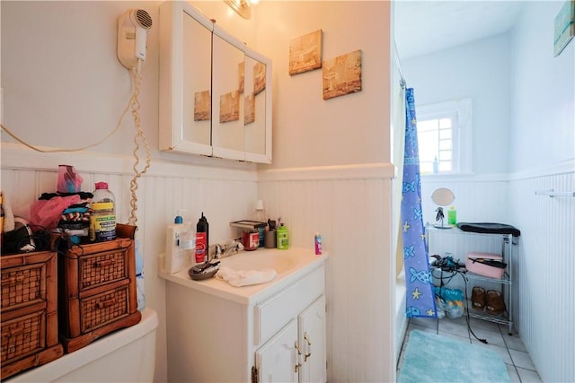 10 Walnut St, East Providence, RI 02914 - full bathroom with wainscoting, vanity, tile patterned floors, and shower / tub combo