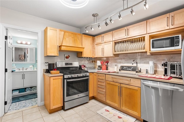 132 Hoffman Ave Unit 116, Cranston, RI 02920 - kitchen featuring appliances with stainless steel finishes, premium range hood, light brown cabinets, and light countertops