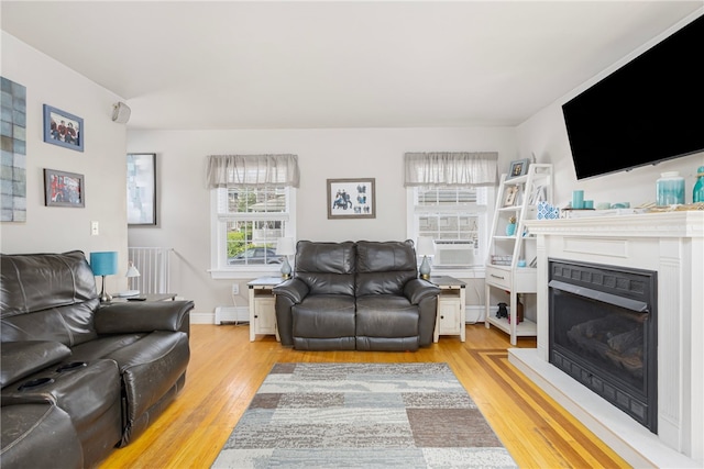 13 Vaughan Ave, Newport, RI 02840 - living room with baseboard heating, light wood finished floors, a fireplace, and cooling unit