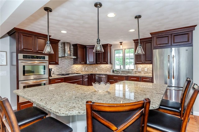 11 Greenbrier Rd, Smithfield, RI 02828 - kitchen featuring appliances with stainless steel finishes, wall chimney exhaust hood, backsplash, a breakfast bar area, and recessed lighting
