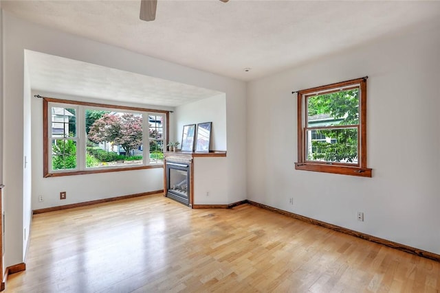 37 Denver Ave, Cranston, RI 02905 - unfurnished room featuring plenty of natural light, light wood-type flooring, a ceiling fan, and a fireplace