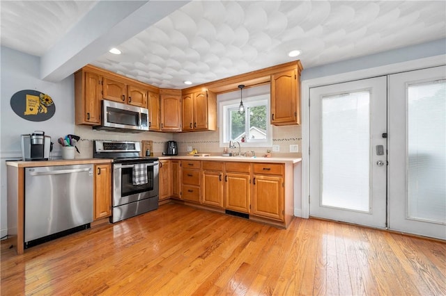 5 Harding St, Coventry, RI 02816 - kitchen with stainless steel appliances, light countertops, light wood-style flooring, brown cabinets, and recessed lighting