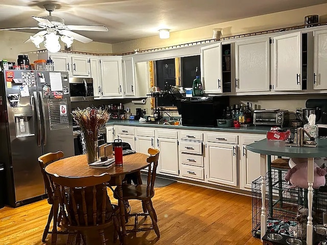 151 Hadde Ave, Cumberland, RI 02864 - kitchen featuring stainless steel appliances, dark countertops, ceiling fan, and light wood-style floors