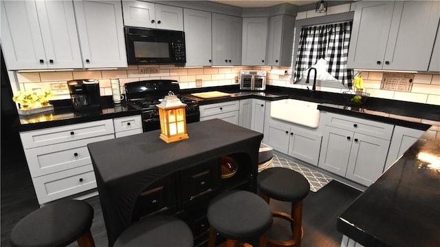 151 Hadde Ave, Cumberland, RI 02864 - kitchen featuring black appliances, decorative backsplash, dark countertops, and dark wood-style floors