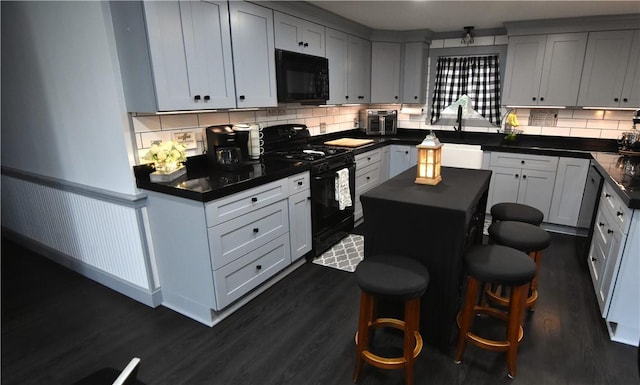 151 Hadde Ave, Cumberland, RI 02864 - kitchen featuring black appliances, dark countertops, dark wood-type flooring, decorative backsplash, and wainscoting