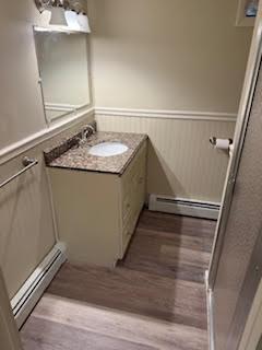 446 Angell Rd, North Providence, RI 02904 - bathroom with baseboard heating, wainscoting, vanity, and wood finished floors