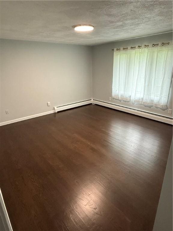 446 Angell Rd, North Providence, RI 02904 - empty room with dark wood-style flooring, baseboard heating, and a textured ceiling