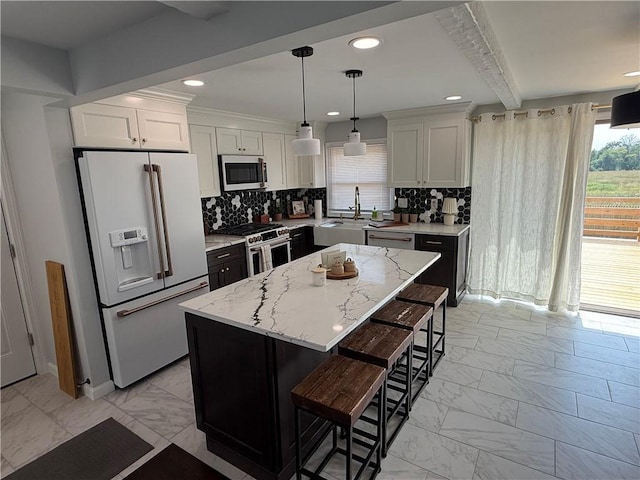 446 Angell Rd, North Providence, RI 02904 - kitchen with stainless steel appliances, light marble finish floors, a breakfast bar area, a kitchen island, and recessed lighting