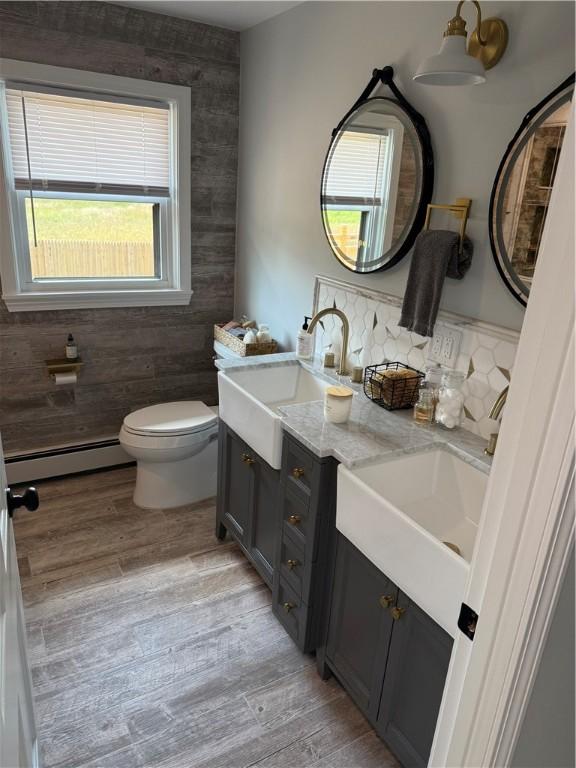 446 Angell Rd, North Providence, RI 02904 - bathroom with a baseboard heating unit, double vanity, and wood finished floors