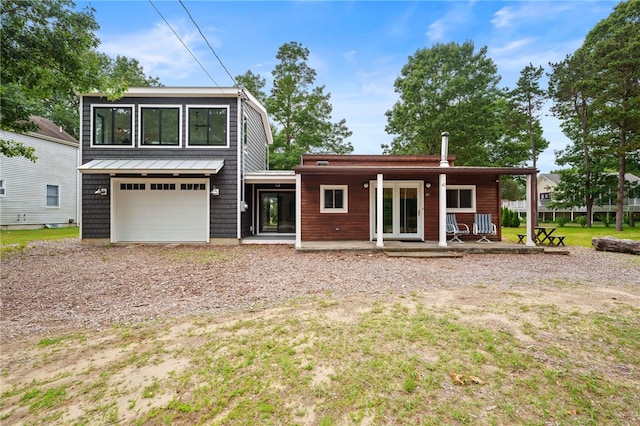 40 Alder Rd, Charlestown, RI 02813 - view of front of property with driveway, an attached garage, a standing seam roof, and a metal roof