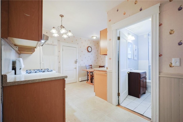 162 Rand St, Central Falls, RI 02863 - kitchen with stove, wallpapered walls, a wainscoted wall, light countertops, and a chandelier