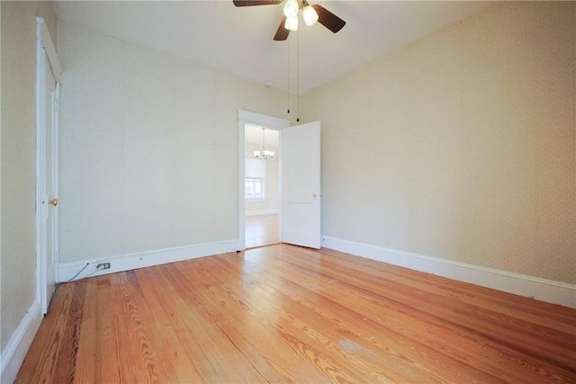 162 Rand St, Central Falls, RI 02863 - empty room with light wood-style flooring, a chandelier, and ceiling fan