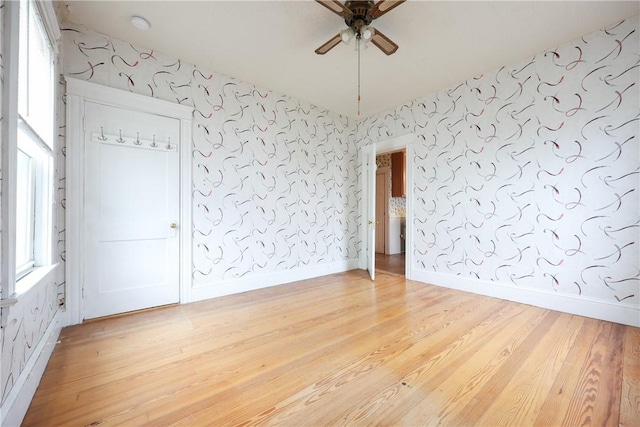 162 Rand St, Central Falls, RI 02863 - spare room with ceiling fan, wallpapered walls, and wood finished floors