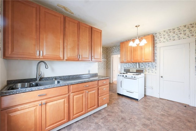 162 Rand St, Central Falls, RI 02863 - kitchen with white range with gas cooktop, wallpapered walls, dark countertops, hanging light fixtures, and brown cabinets