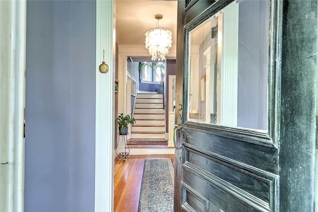 179 Elmgrove Ave, Providence, RI 02906 - entryway with a chandelier, crown molding, stairway, and wood finished floors