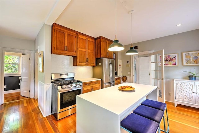 179 Elmgrove Ave, Providence, RI 02906 - kitchen with appliances with stainless steel finishes, brown cabinetry, light wood-type flooring, and light countertops