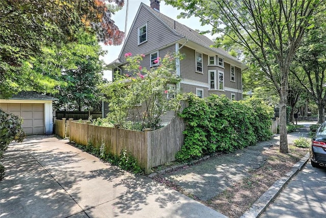 179 Elmgrove Ave, Providence, RI 02906 - view of home's exterior with driveway, a chimney, and an outbuilding