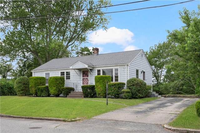21 Parsonage Dr, Warwick, RI 02889 - view of front facade featuring a chimney, a front lawn, driveway, and a shingled roof