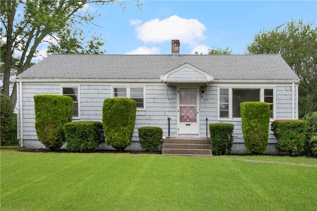 21 Parsonage Dr, Warwick, RI 02889 - view of front of house featuring a chimney, a front yard, and roof with shingles
