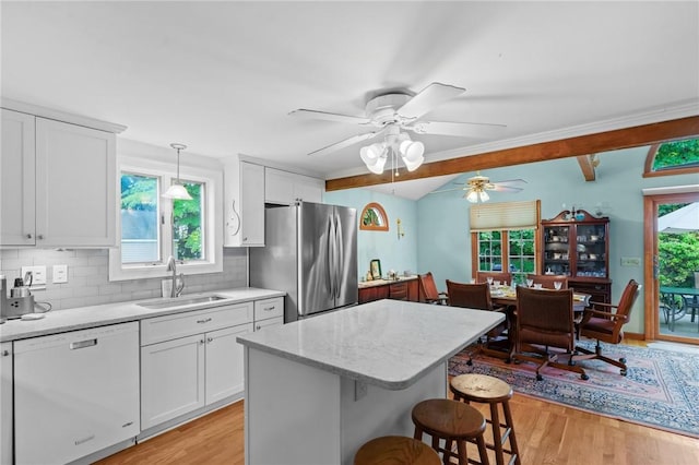 13 Welcome Rd, Smithfield, RI 02917 - kitchen featuring dishwasher, freestanding refrigerator, light wood-type flooring, a breakfast bar area, and plenty of natural light