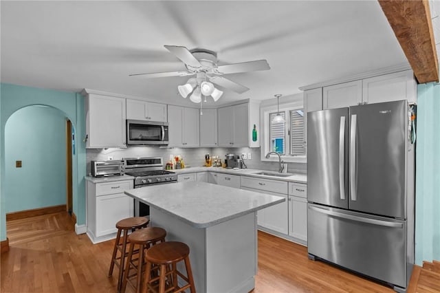 13 Welcome Rd, Smithfield, RI 02917 - kitchen with stainless steel appliances, arched walkways, and light wood-style floors