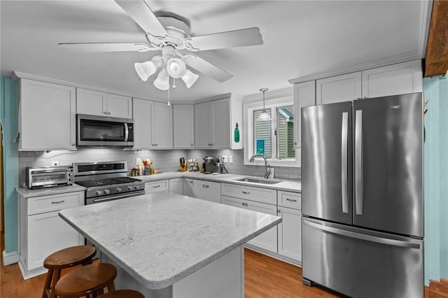 13 Welcome Rd, Smithfield, RI 02917 - kitchen with appliances with stainless steel finishes, light wood-type flooring, backsplash, a ceiling fan, and white cabinets