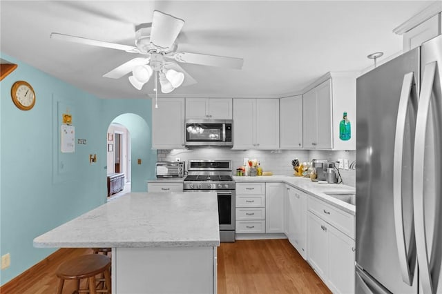 13 Welcome Rd, Smithfield, RI 02917 - kitchen featuring appliances with stainless steel finishes, arched walkways, a center island, and tasteful backsplash