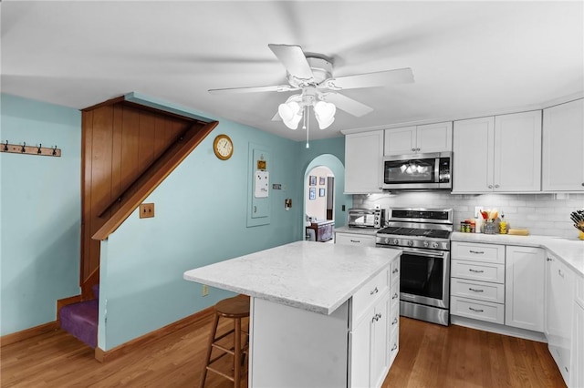13 Welcome Rd, Smithfield, RI 02917 - kitchen featuring appliances with stainless steel finishes, arched walkways, backsplash, and dark wood-style floors
