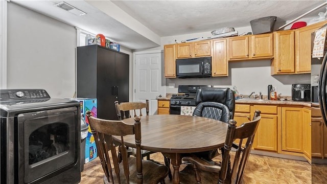 65 River St, West Warwick, RI 02893 - kitchen featuring black appliances, washer / clothes dryer, and light countertops