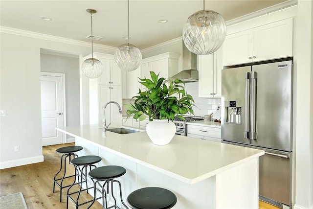 20 Kettle Point Ave, East Providence, RI 02914 - kitchen with stainless steel appliances, wall chimney range hood, a kitchen island with sink, light wood-style flooring, and decorative backsplash