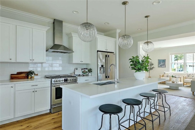 20 Kettle Point Ave, East Providence, RI 02914 - kitchen featuring wall chimney exhaust hood, appliances with stainless steel finishes, light wood-type flooring, a breakfast bar area, and white cabinetry