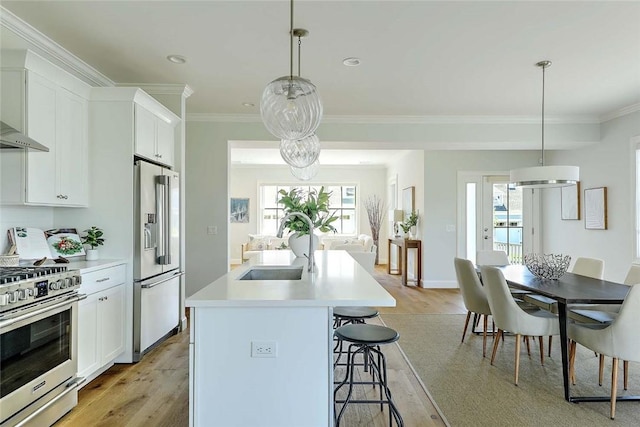 20 Kettle Point Ave, East Providence, RI 02914 - kitchen featuring stainless steel appliances, light wood-style flooring, a breakfast bar area, ornamental molding, and a kitchen island with sink