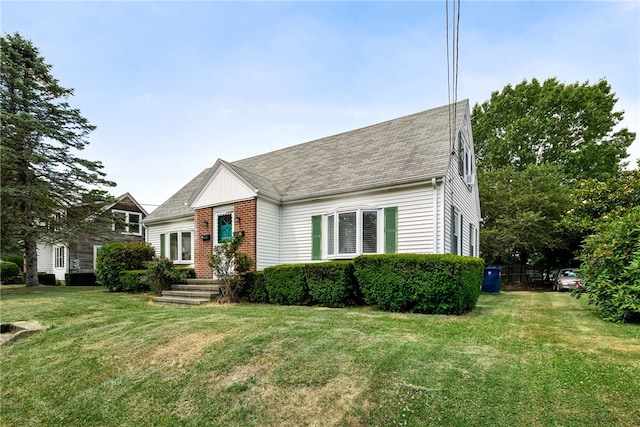 15 Preston Dr, North Kingstown, RI 02852 - view of front of home featuring a front lawn, a shingled roof, and brick siding
