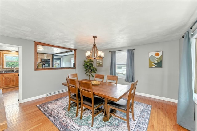 82 Martin St, East Providence, RI 02914 - dining room featuring a chandelier, light wood-type flooring, and plenty of natural light