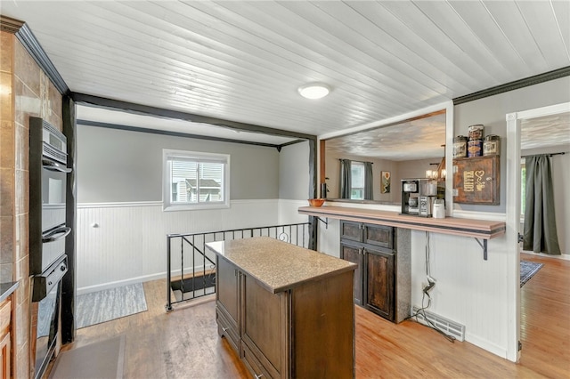 82 Martin St, East Providence, RI 02914 - kitchen with a chandelier, oven, wainscoting, a warming drawer, and light countertops