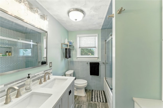 82 Martin St, East Providence, RI 02914 - bathroom with tile walls, double vanity, and enclosed tub / shower combo